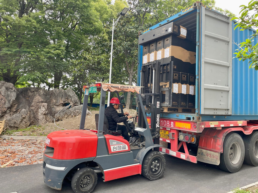 Workers at DAMAXED factory driving forklifts to load customized e-bikes for shipment.