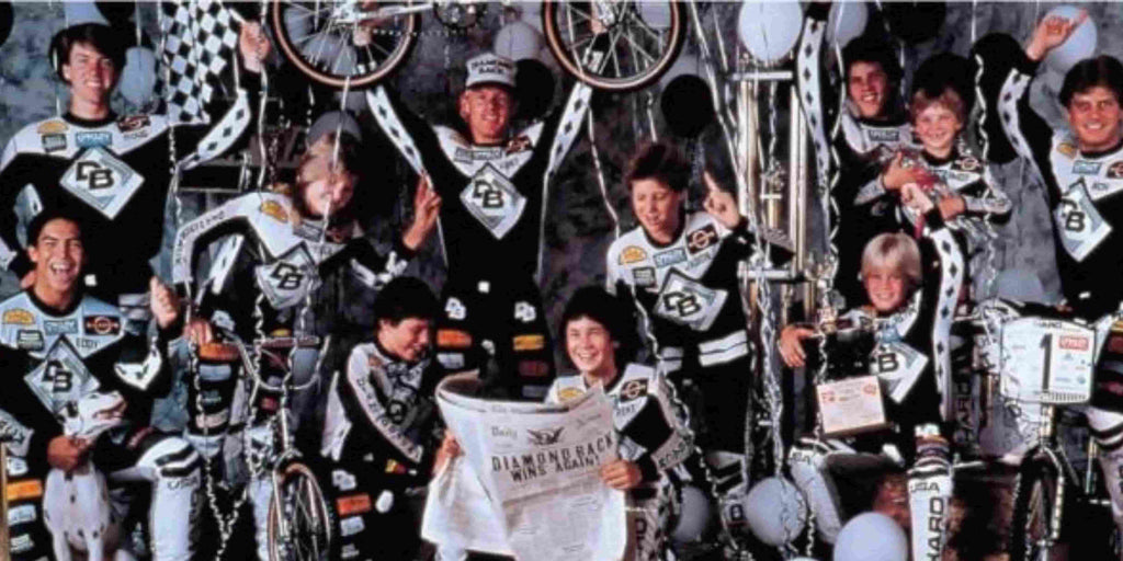 DIAMONDBACK team members holding a bike, smiling with arms raised, celebrating their international tournament victory