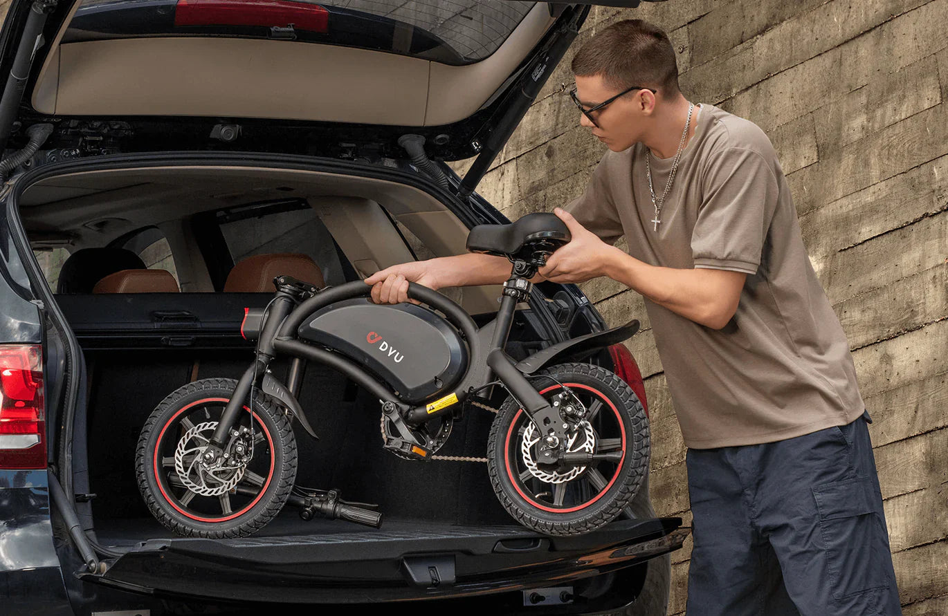 Man loading a folded dyu d3f foldable electric bike into the trunk of a car.