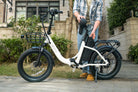 Person holding a folded C9 foldable electric bike in an outdoor setting
